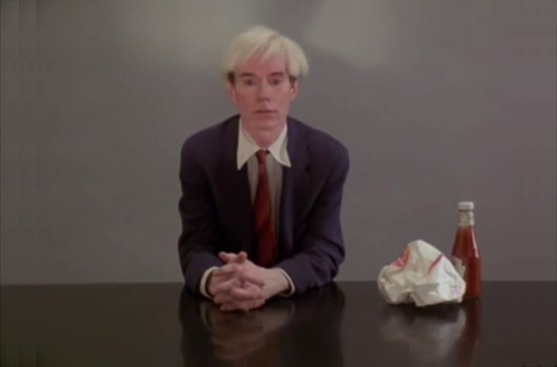 Still from Andy Warhol eating a Hamburger from the film 66 Scenes from America (1982) by Jørgen Leth. Courtesy the artist and Louisiana Museum of Modern Art.